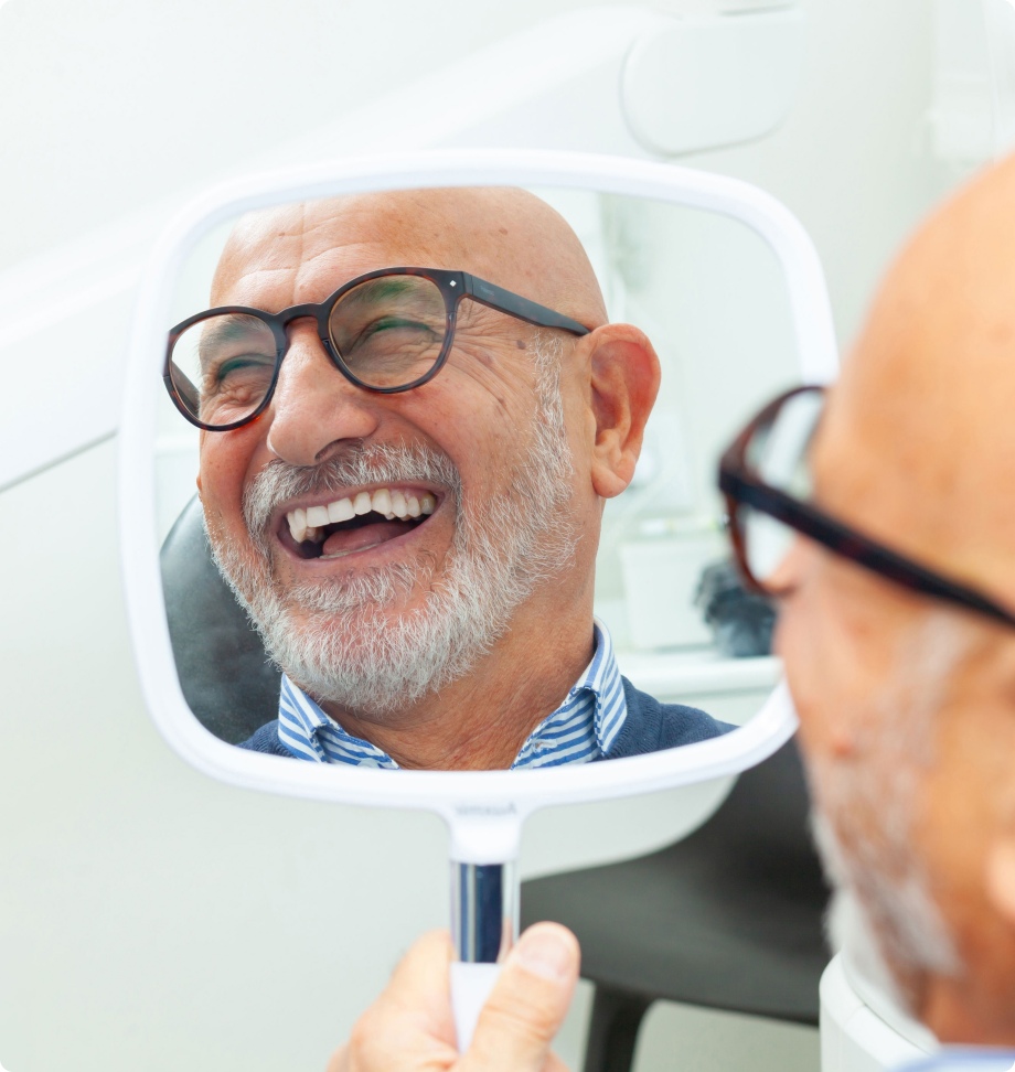Mature man looking at mirror and laughing